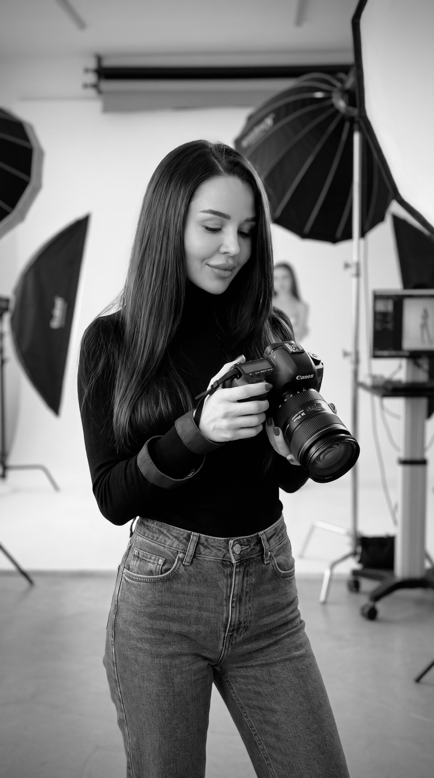 Cristina, founder of Well Bred Studio, holding a camera in a photography studio